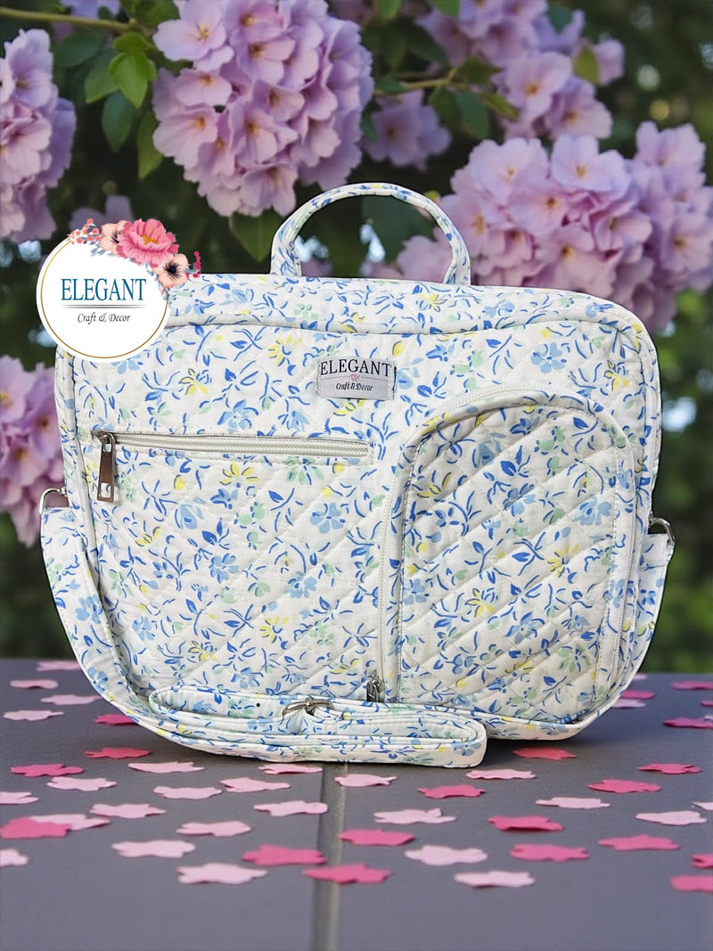 A stylish white and blue quilted bag featuring multiple zip pockets and a versatile shoulder strap.