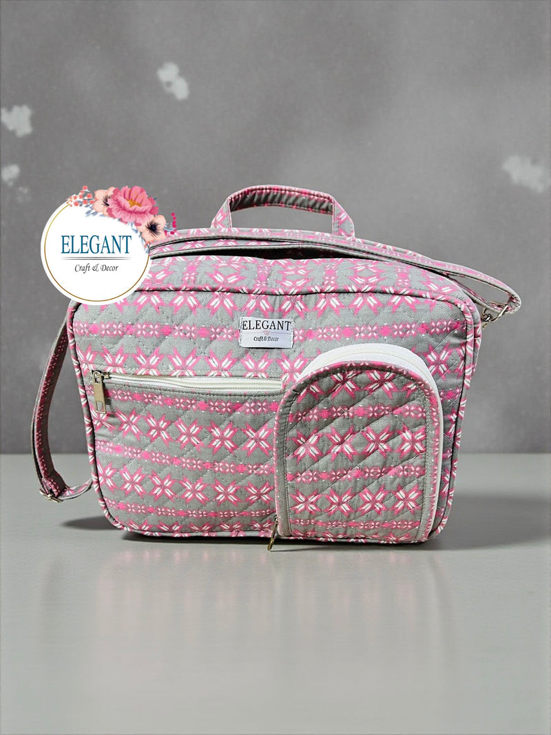 A stylish pink and grey quilted bag featuring multiple zip pockets and a versatile shoulder strap.