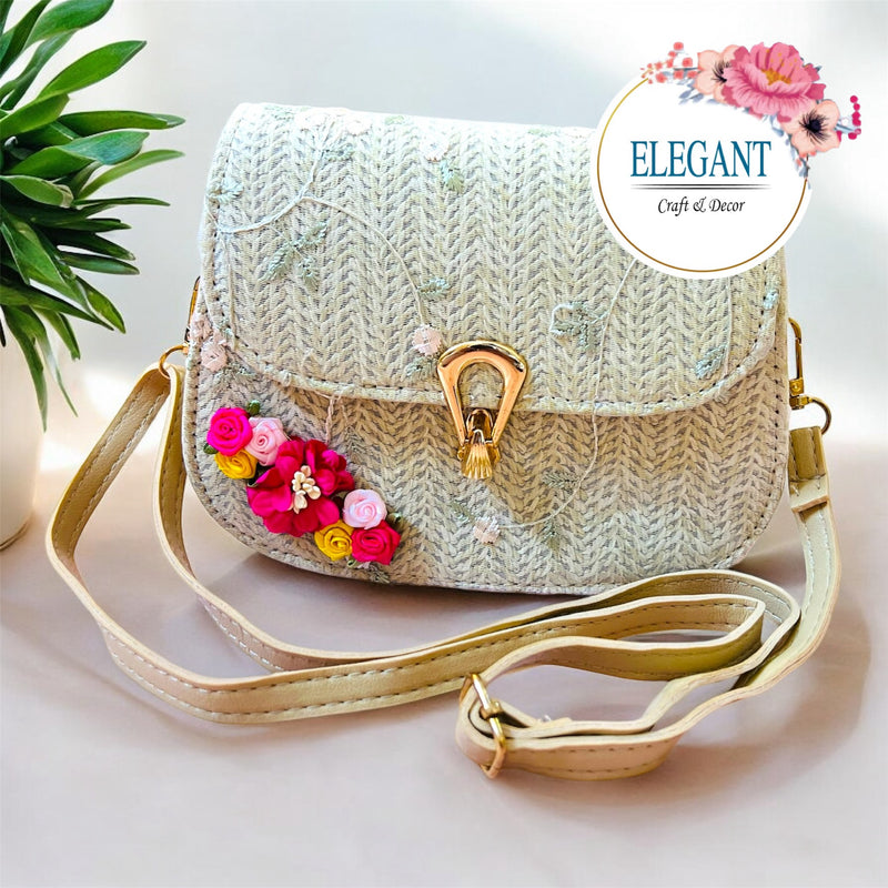 A classy handwoven straw clutch with soft neutral tones, adorned with delicate floral embroidery and a sleek gold clasp—perfect for a chic, minimal yet elegant look.