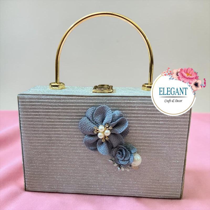 Elegant rectangular box-style evening clutch featuring a shimmering, silver textured finish with horizontal ribbing.