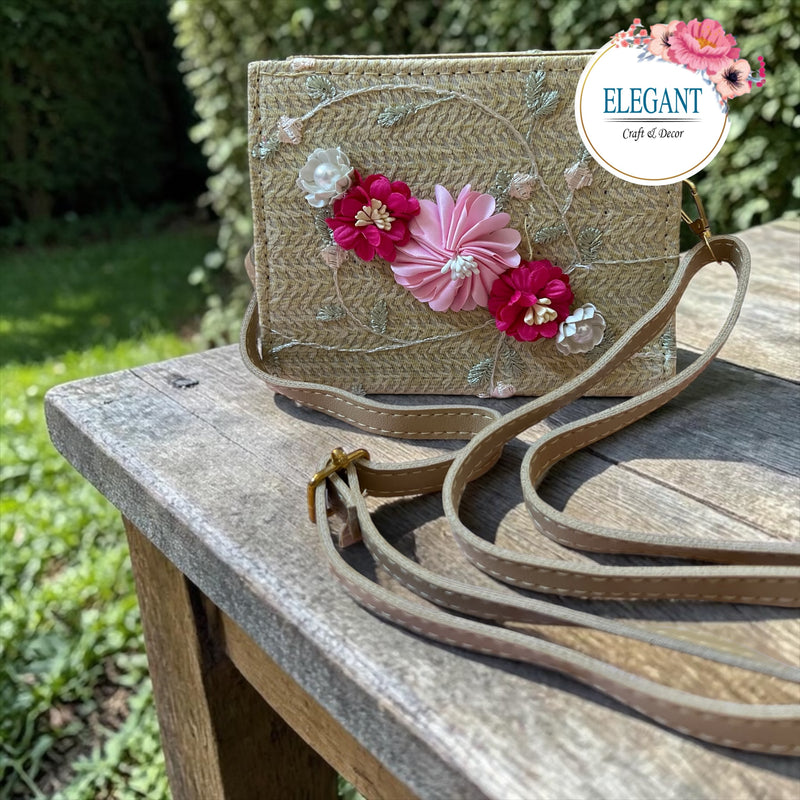 Beige woven box bag features vibrant 3D flowers and delicate embroidery. It includes a matching adjustable strap, making it a stylish and versatile accessory for any special occasion.