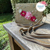 Beige woven box bag features vibrant 3D flowers and delicate embroidery. It includes a matching adjustable strap, making it a stylish and versatile accessory for any special occasion.