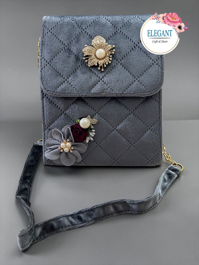 Elegant seude purse with long metal chain and metal embellishment with a touch of floral bunch